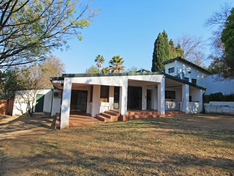 Rear view of the cottage featuring a covered patio area with tiled flooring, security gates, and direct access to the garden.