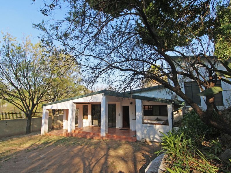 Rear view of the cottage featuring a covered patio area with tiled flooring, security gates, and access to the surrounding garden space.