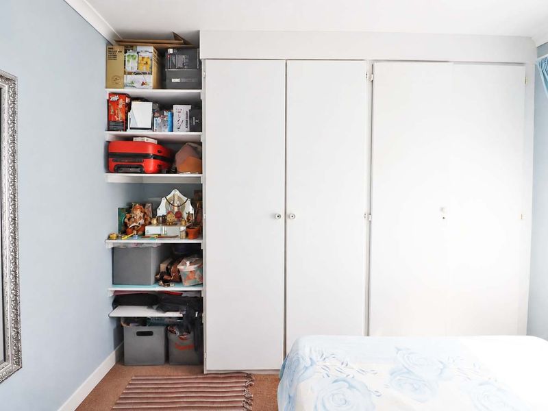 Bedroom featuring a large built-in wardrobe with integrated open shelving for storage.