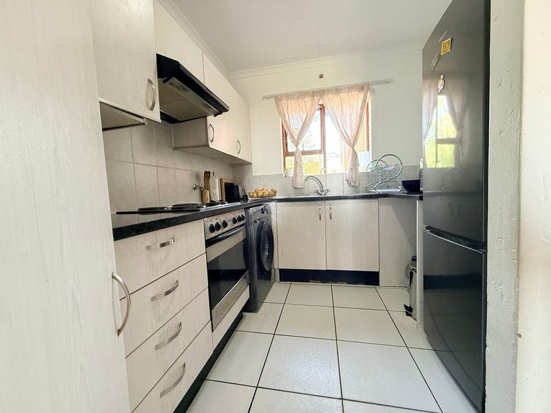 A functional kitchen featuring built-in cabinetry, a built-in oven with extractor fan, tiled backsplash, and tiled flooring.