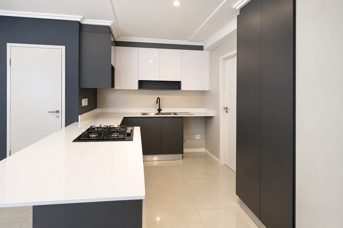 Modern kitchen featuring sleek two-tone cabinetry, quartz countertops, a gas hob, and high-quality tiled flooring in a clean, contemporary layout.