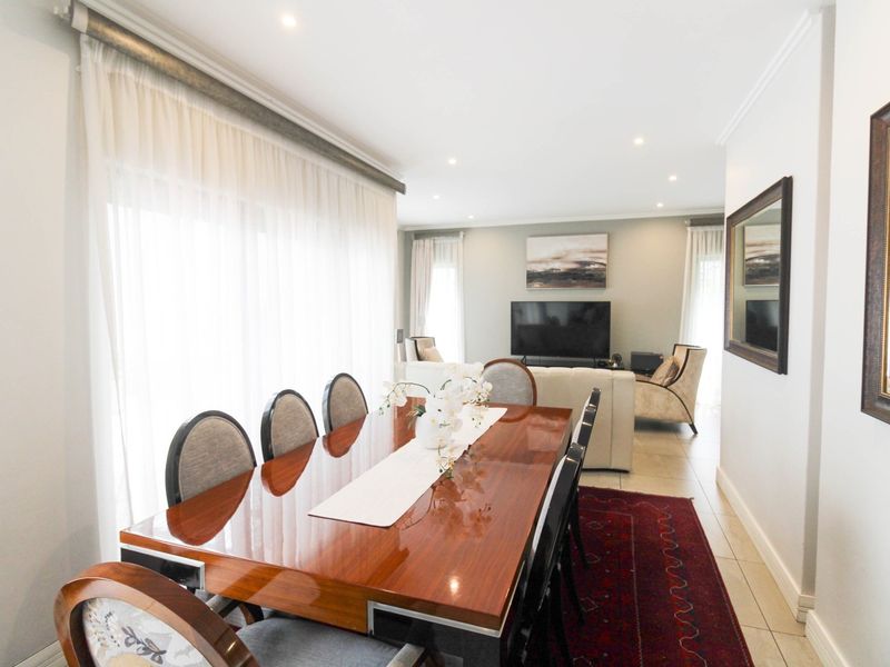 Spacious open-plan living and dining area featuring tiled floors, recessed lighting, and large sliding glass doors that provide ample natural light.