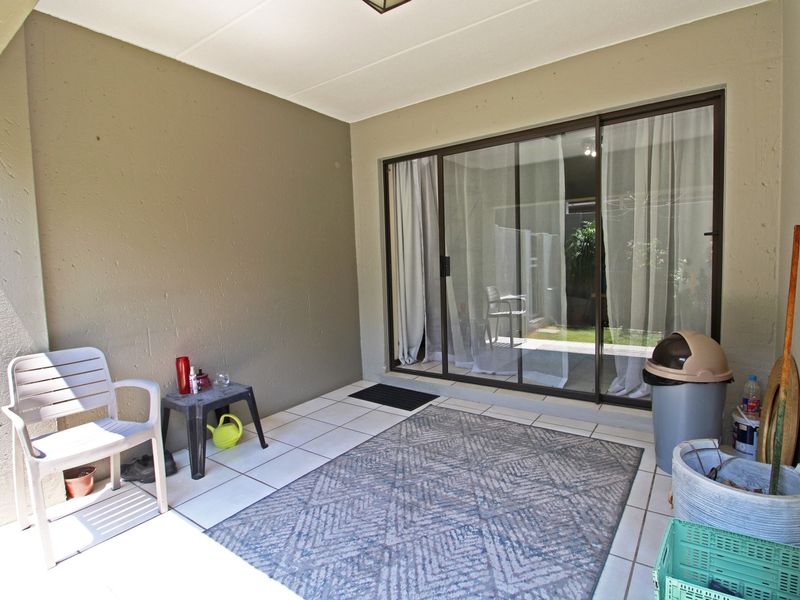 A covered patio area featuring tiled flooring and large sliding glass doors providing access to the interior living space.