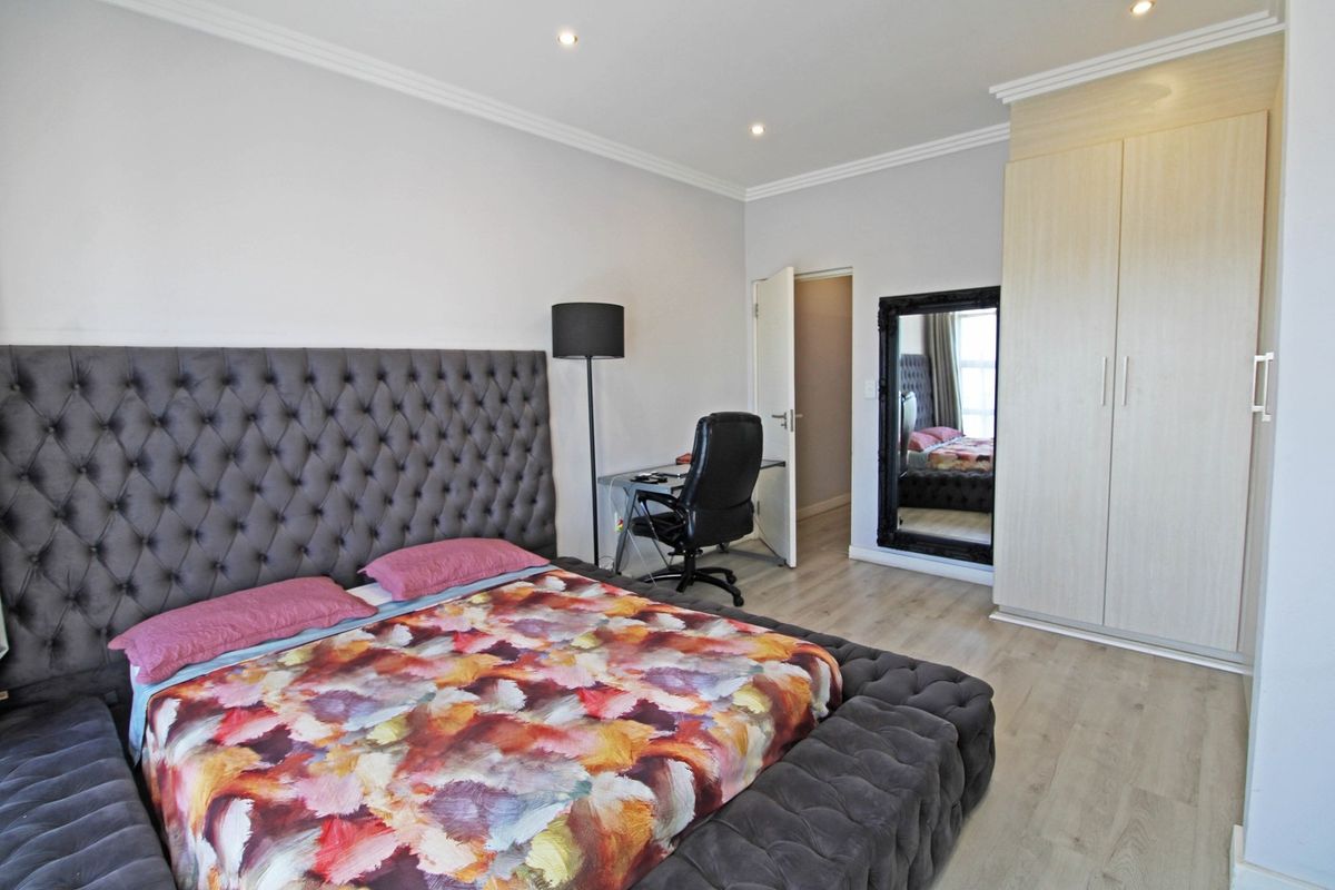 A well-maintained bedroom featuring light wood-look flooring, recessed ceiling lighting, and built-in cabinetry.