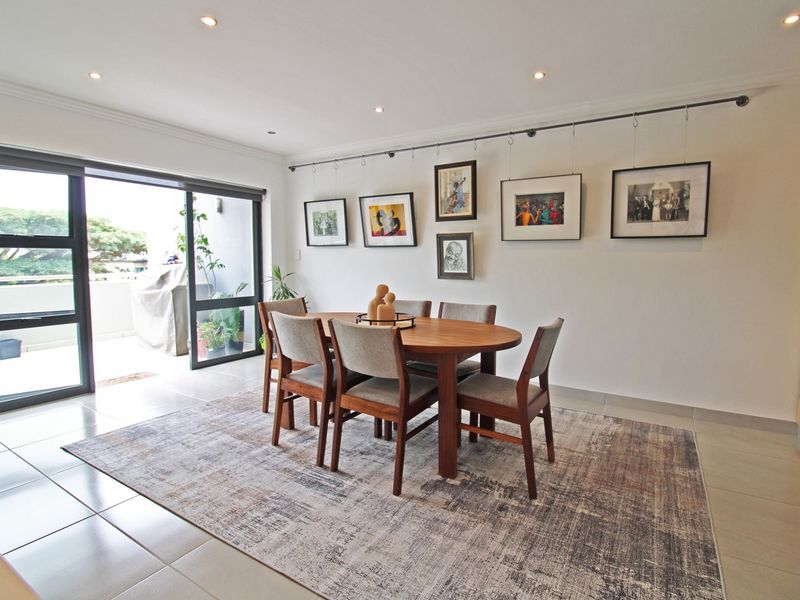 Bright dining area featuring tiled floors, recessed lighting, and a sliding glass door providing access to the balcony.