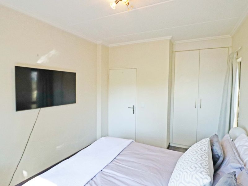 A bedroom featuring neutral walls, built-in wardrobe storage, and coving detail.