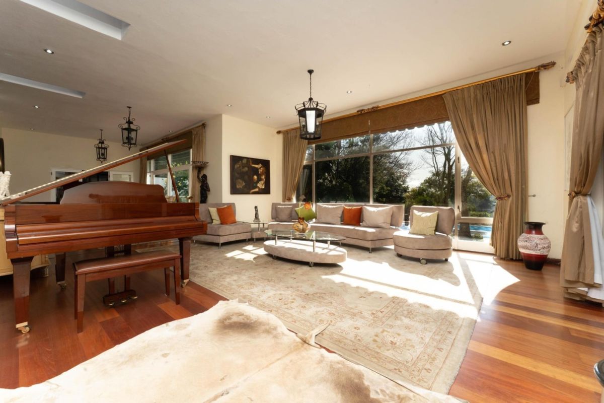 Spacious living room featuring polished hardwood flooring, recessed lighting, and large sliding glass doors that provide ample natural light and garden views.