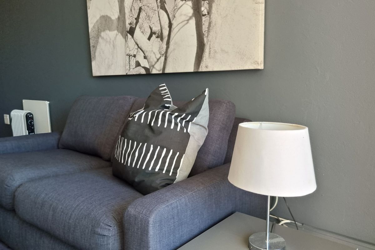 A close-up view of a living room area featuring dark grey painted walls.