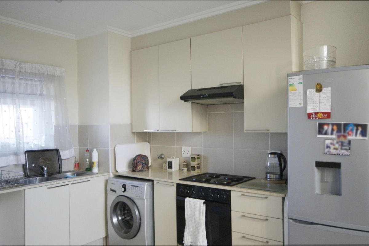 A functional kitchen featuring built-in cabinetry, a tiled backsplash, an integrated oven and hob, and a stainless steel sink.