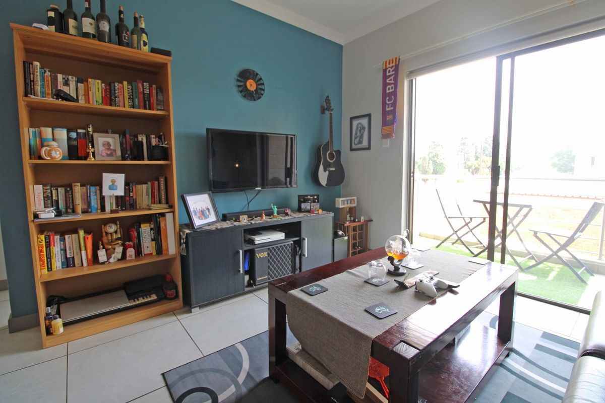A living room featuring tiled flooring and a large sliding glass door providing access to an outdoor balcony area.