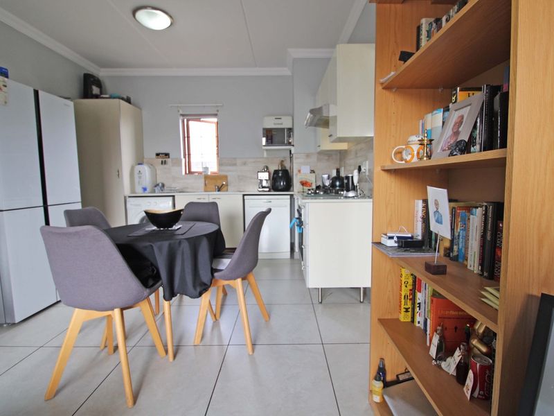 Open plan kitchen and dining area featuring tiled flooring, built-in cabinetry, and functional workspace.
