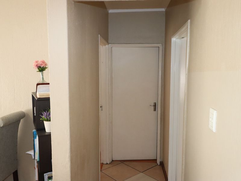 A functional hallway featuring tiled flooring and neutral wall finishes, providing access to adjacent rooms within the apartment.