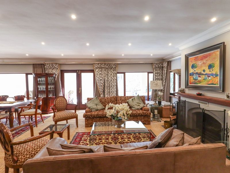 Spacious living room featuring a fireplace with a timber mantelpiece, recessed downlighting, and large sliding glass doors providing access to the outdoor area.
