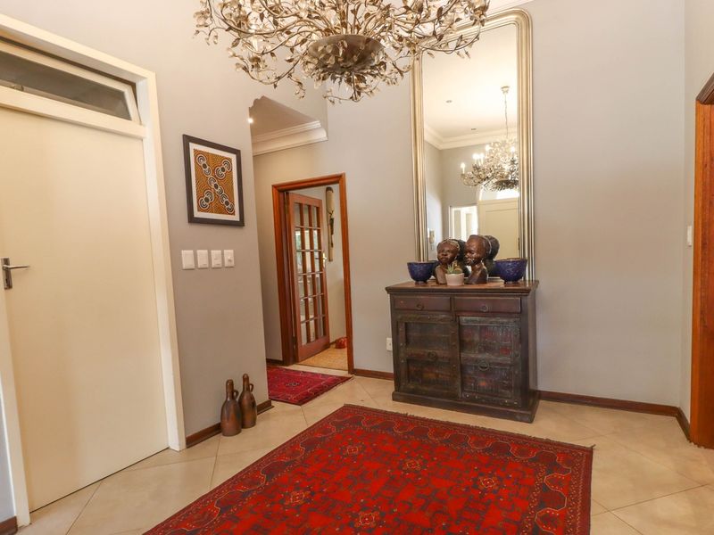 A welcoming entrance hall featuring tiled flooring, neutral wall tones, and classic wooden door frames, creating a bright and inviting transition space.