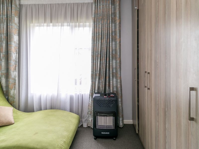 A bedroom featuring neutral-toned built-in cupboards and carpeted flooring, providing ample storage space and a comfortable atmosphere.