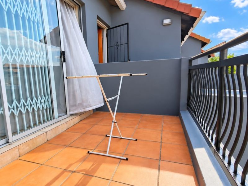 A private balcony featuring tiled flooring, a metal balustrade, and direct access to the interior through a sliding glass door.