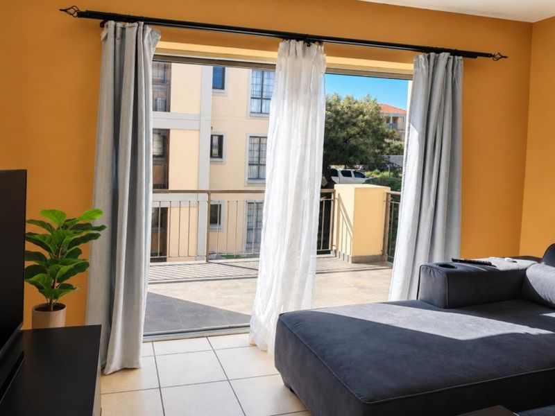 Living room featuring tiled flooring and a large sliding glass door providing access to an outdoor balcony area.