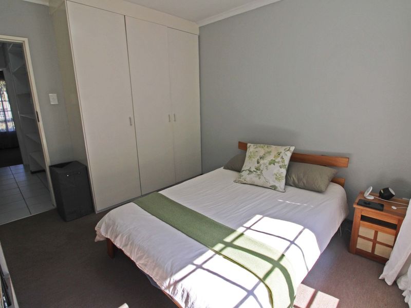 A functional bedroom featuring a built-in wardrobe and neutral wall finishes, offering a comfortable and practical living space.