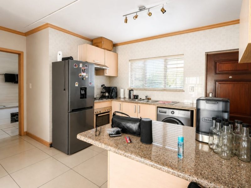 Functional kitchen featuring granite countertops, built-in cabinetry, integrated oven, and tiled flooring, offering a practical layout for daily meal preparation.