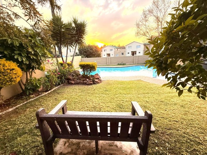 A well-maintained outdoor pool area featuring a swimming pool, paved surround, and established garden landscaping, perfect for relaxation and outdoor enjoyment.