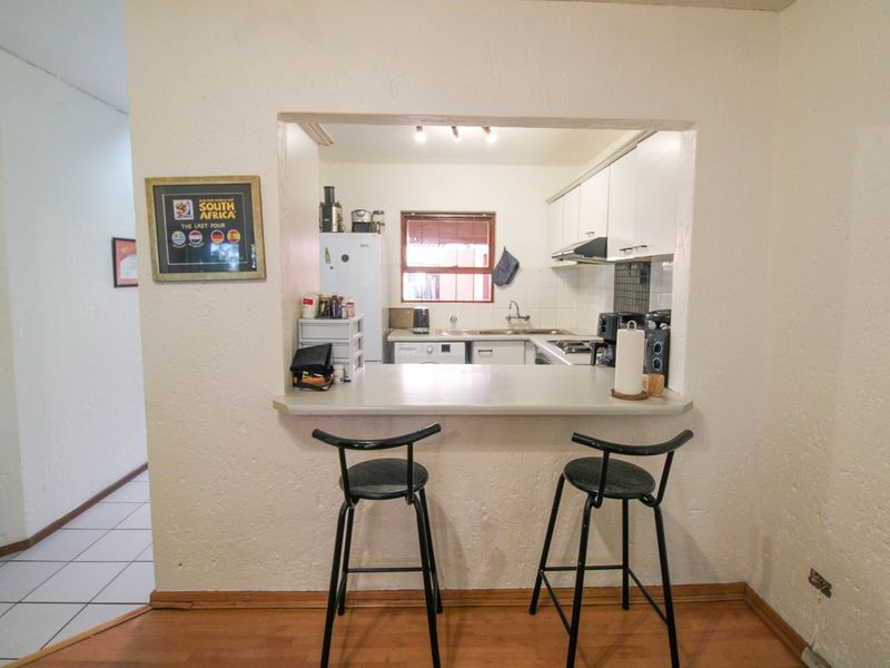 Open plan kitchen featuring a breakfast bar, built-in cabinetry, and functional workspace, connecting seamlessly to the living area.