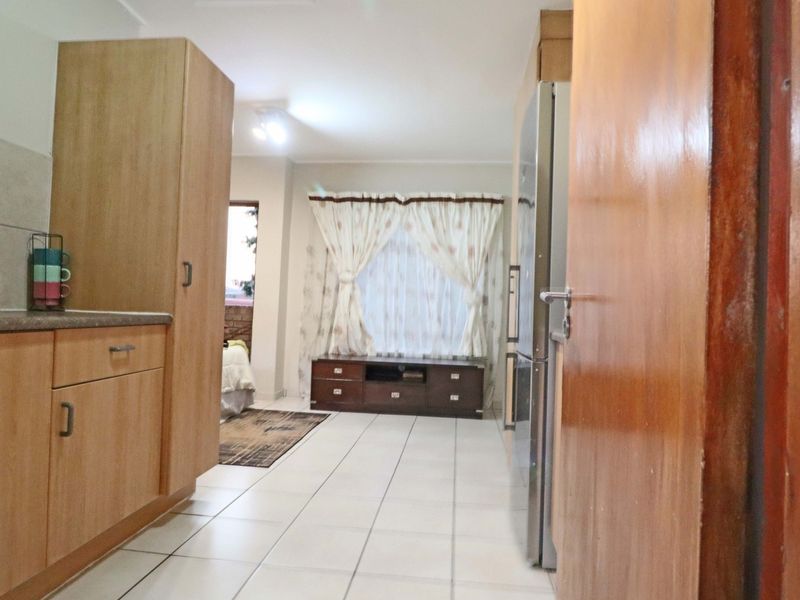 Open plan living area featuring tiled flooring and built-in cabinetry, creating a functional space that connects the kitchen and living zones.