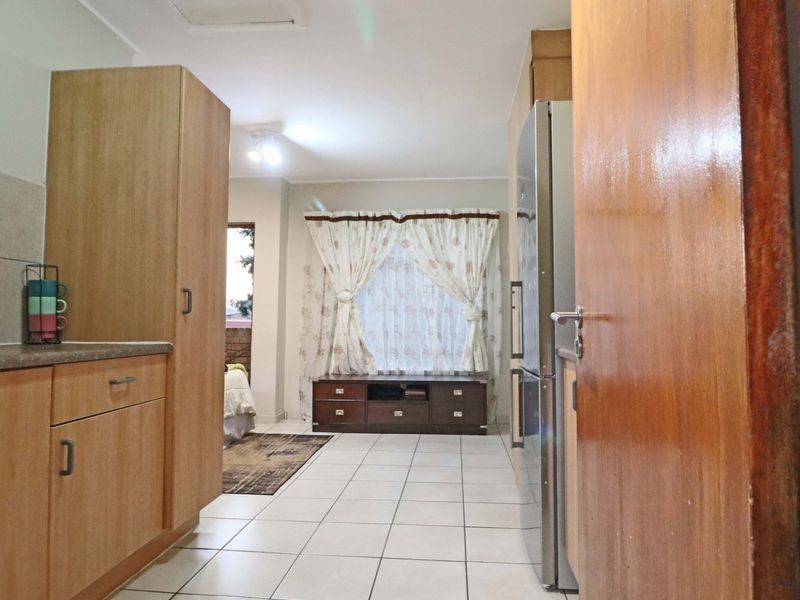 Open-plan living area featuring tiled flooring and built-in cabinetry, creating a functional space that connects the kitchen and living zones.