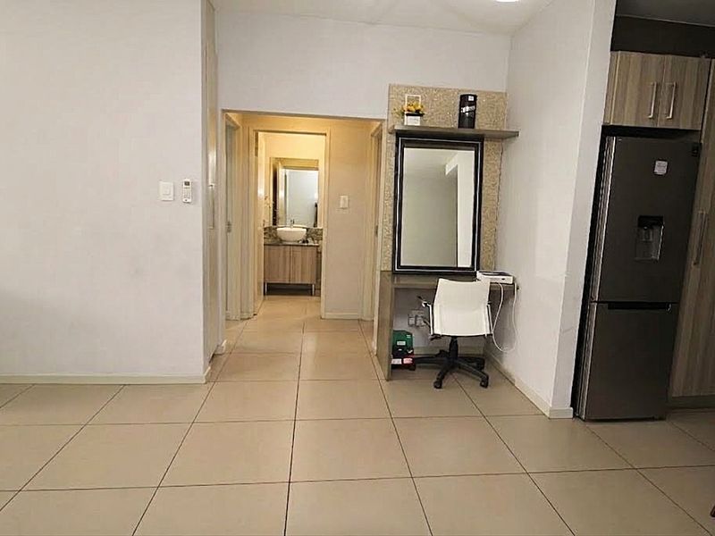 Open plan living area featuring tiled flooring, built-in vanity unit, and access to the bathroom, showcasing a functional and well-maintained interior layout.
