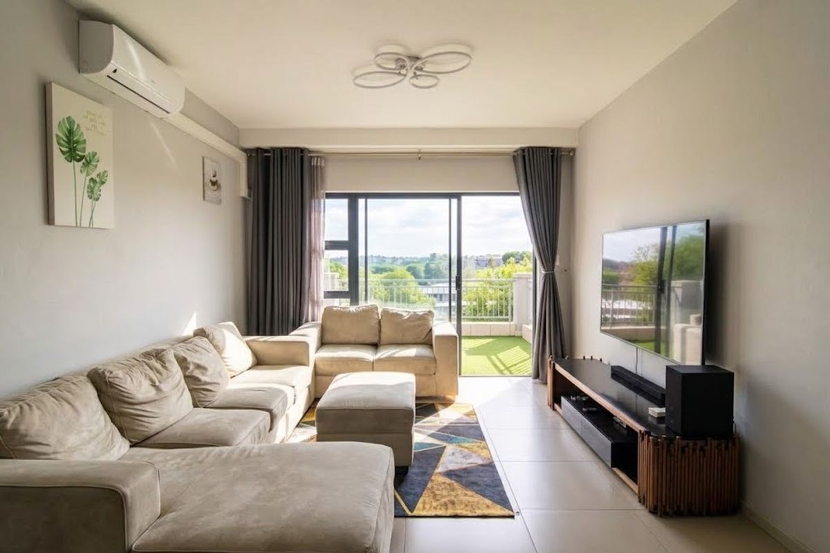 A bright and well-maintained living room featuring tiled floors, a split-system air conditioner, and direct access to a balcony through sliding glass doors.