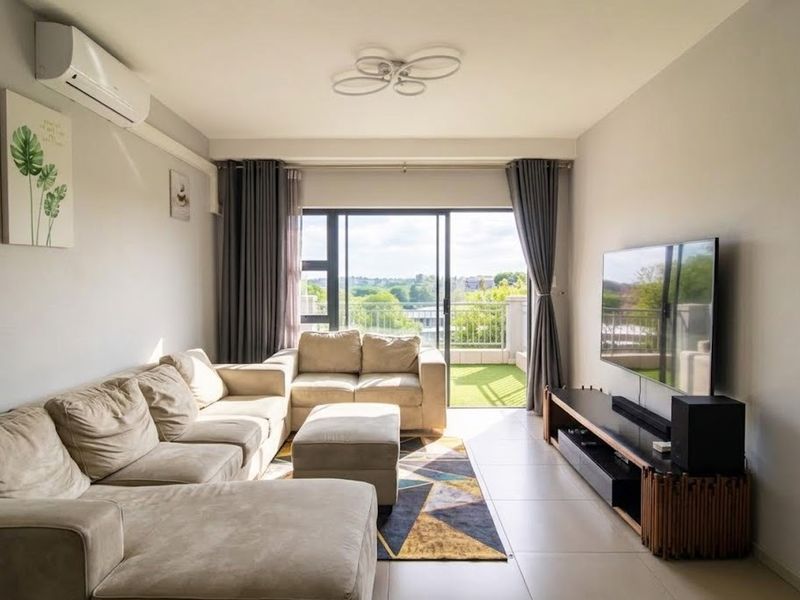 A bright and well-maintained living room featuring tiled floors, a split-system air conditioner, and direct access to a balcony through sliding glass doors.