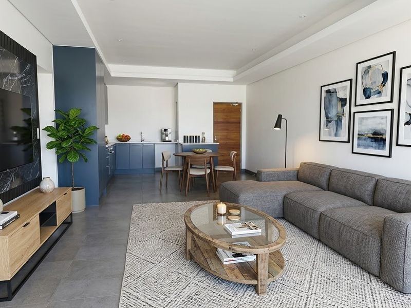 Modern open-plan living area featuring a marble-look feature wall, sleek cabinetry, and neutral tiled flooring, creating a cohesive and contemporary living space.