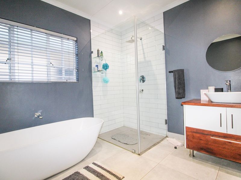 Modern bathroom featuring a freestanding bathtub, a walk-in shower with subway tiling, and a contemporary vanity with a vessel sink.