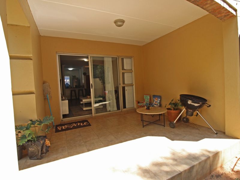 A covered patio area featuring tiled flooring and a sliding glass door providing access to the interior living space.