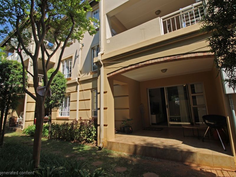Rear view of the apartment building featuring a ground-floor covered patio with sliding door access and an upper-level balcony.