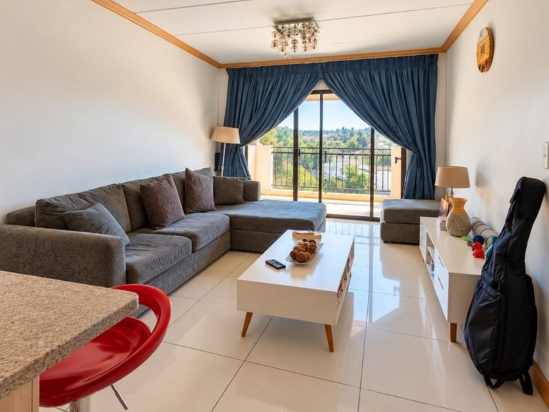 Bright living room featuring large format floor tiles, coved ceiling details, and a sliding glass door providing direct access to a private balcony.