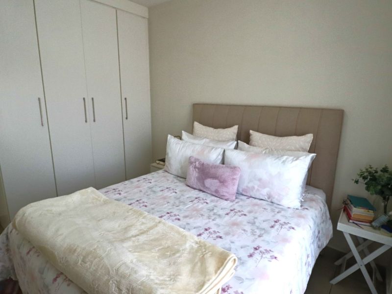 A well-maintained bedroom featuring a neutral color palette and a spacious built-in wardrobe for efficient storage.