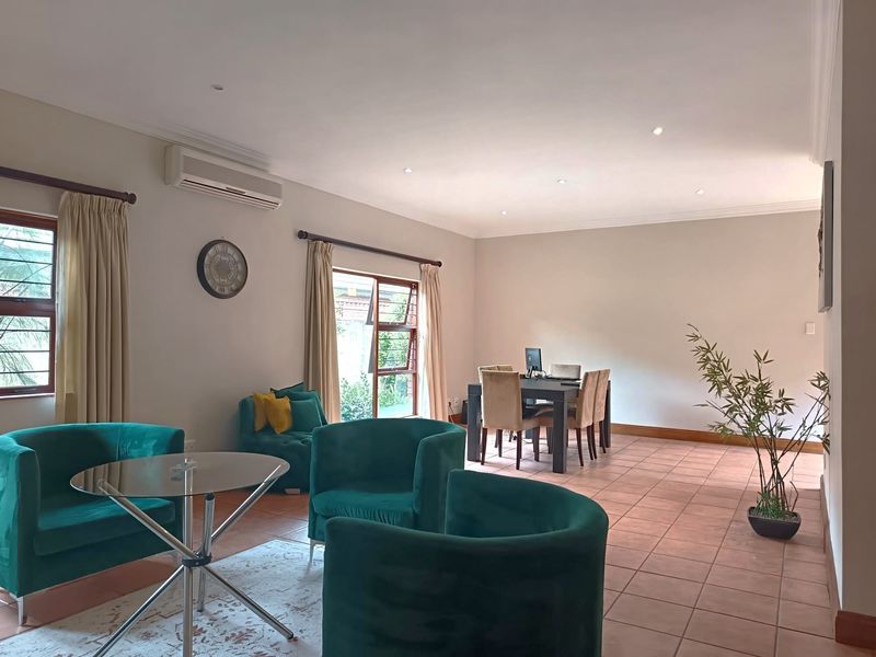 Spacious open-plan living and dining area featuring tiled flooring, recessed lighting, and air conditioning, offering a versatile layout for comfortable living.