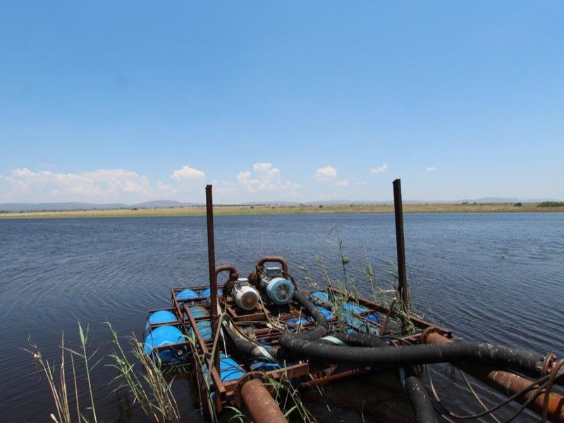 Floating pump station infrastructure located on the farm dam, featuring electric motors and irrigation piping for water management.