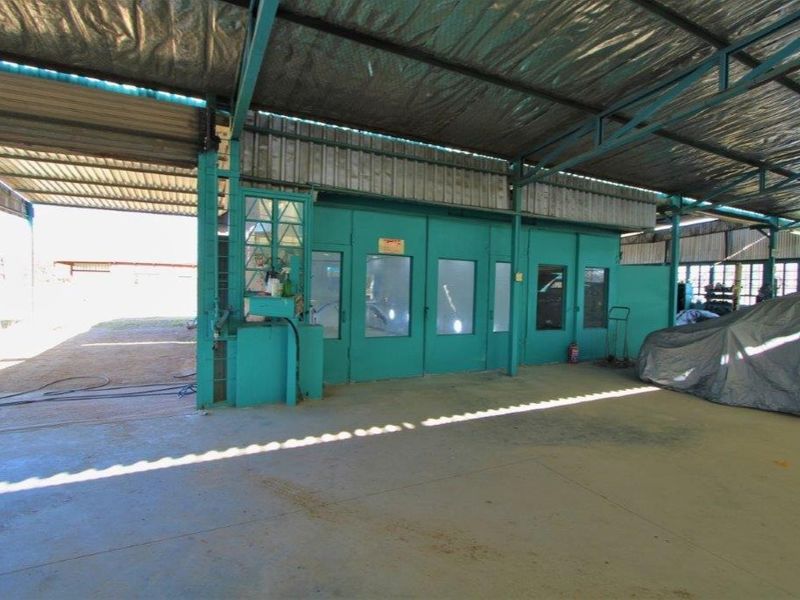 Industrial utility space featuring a large covered area with concrete flooring and a built-in spray booth enclosure.