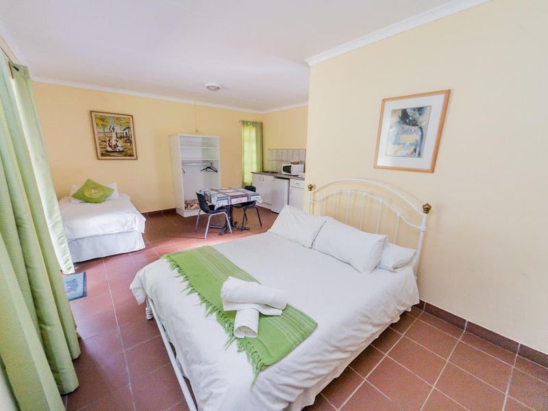 Open-plan studio space featuring tiled flooring, a kitchenette area, and neutral wall finishes, suitable for flexible living arrangements.
