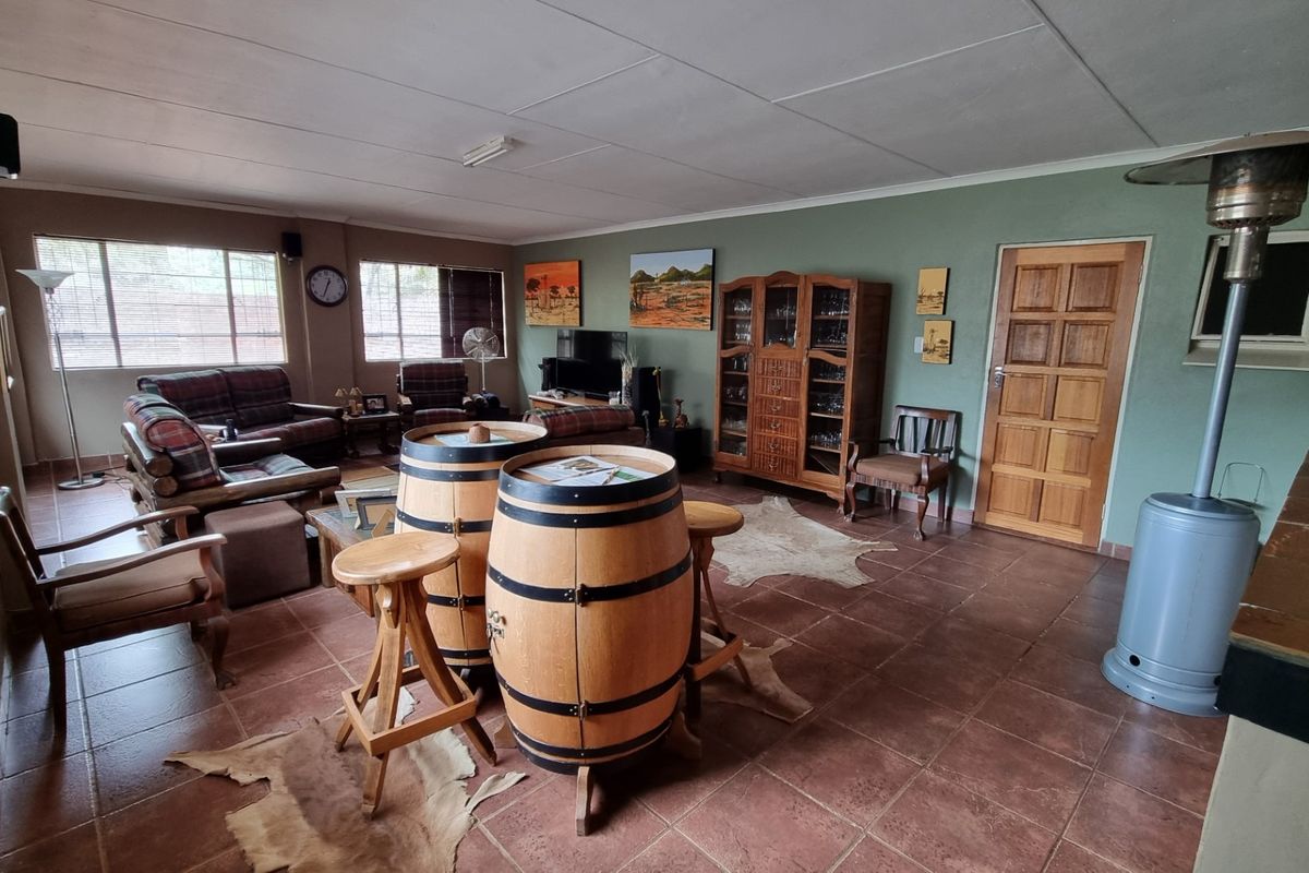 Spacious living area featuring tiled flooring, timber door, and large windows, offering a versatile layout suitable for comfortable family living.