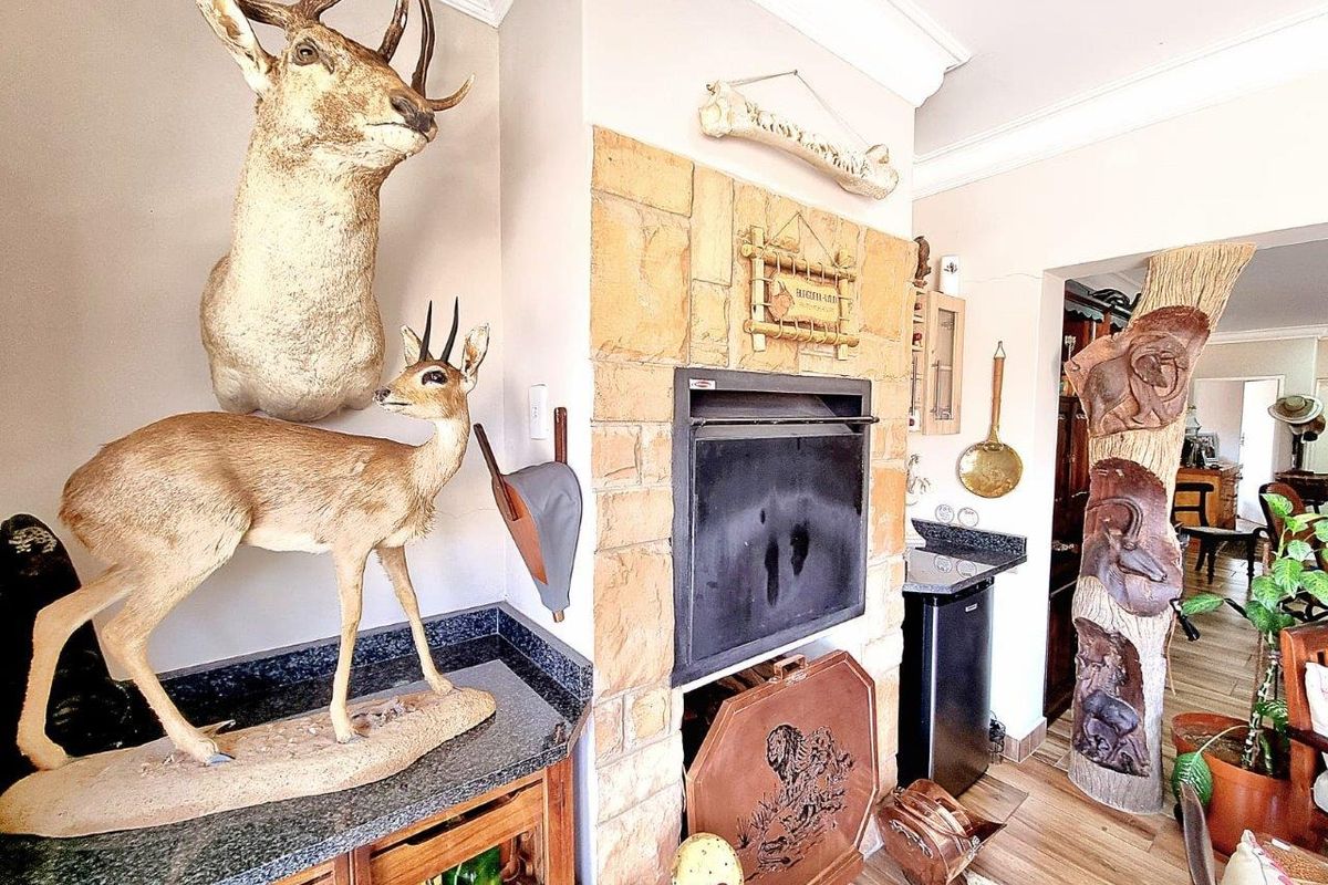 A living area featuring a stone-clad built-in fireplace, granite countertops, and wood-look flooring, creating a rustic and cozy atmosphere.