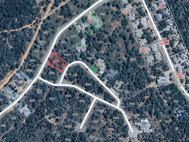 Aerial view of a vacant residential plot within a developed estate, highlighting its location, road access, and surrounding landscape.