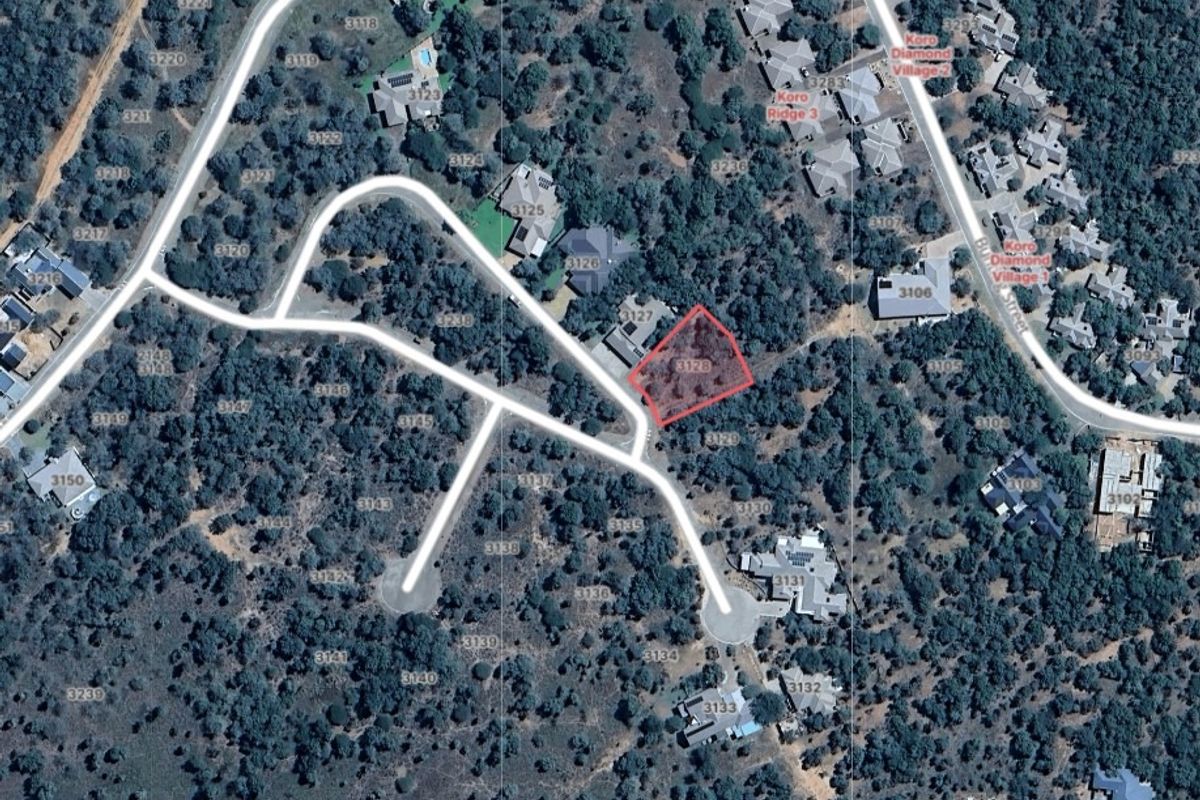 Aerial view of a vacant residential land plot situated within a developed estate, featuring established vegetation and direct access to paved roads.