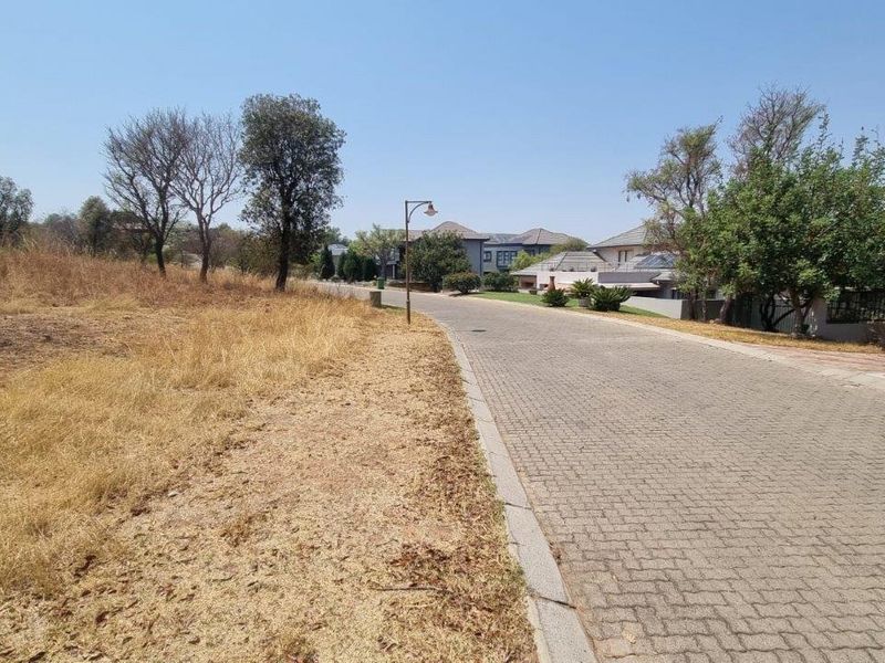 A view of the paved street and verge adjacent to the vacant residential land, showing established neighbourhood infrastructure.