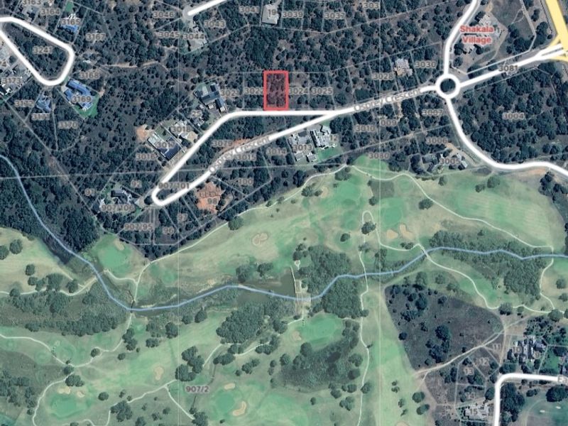 Aerial view of a vacant residential land plot highlighted in red, situated within a developed estate near a golf course.