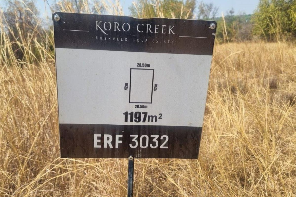 A property signage board displaying the dimensions and erf number for a vacant residential plot in Koro Creek Bushveld Golf Estate.