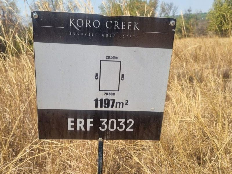 A property signage board displaying the dimensions and erf number for a vacant residential plot in Koro Creek Bushveld Golf Estate.
