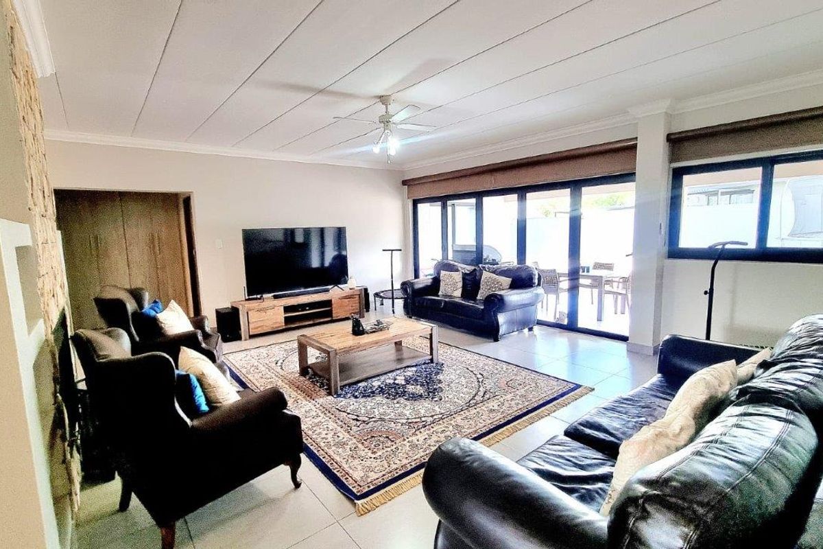 Spacious living room featuring large sliding glass doors that provide abundant natural light and seamless access to the outdoor patio area.