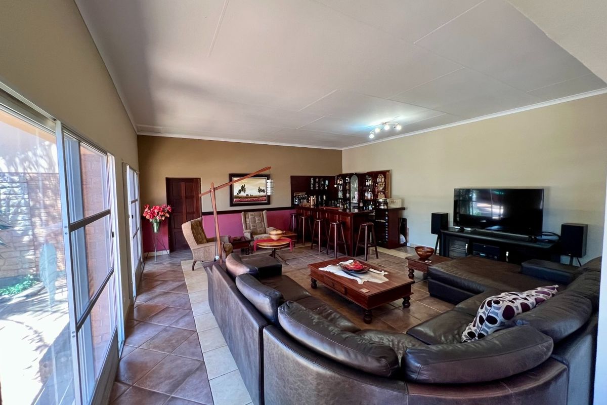 Spacious living area featuring tiled flooring, large sliding glass doors for natural light, and a built-in bar area.
